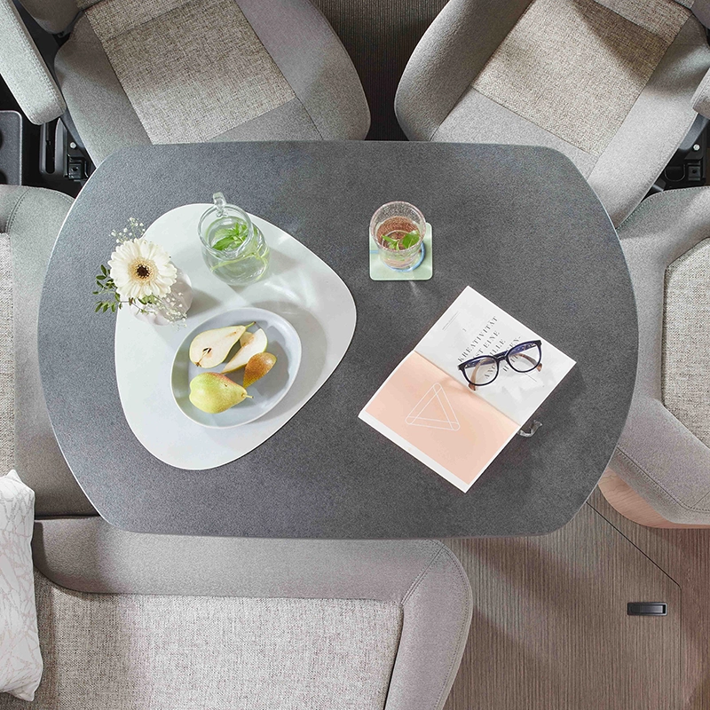 gedeckter Wohnraumtisch mit grauer Sitzgruppe