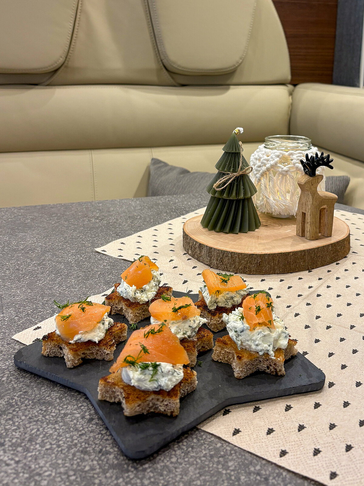 Crostini al salmone su un piatto da portata a forma di stella con sfondo natalizio