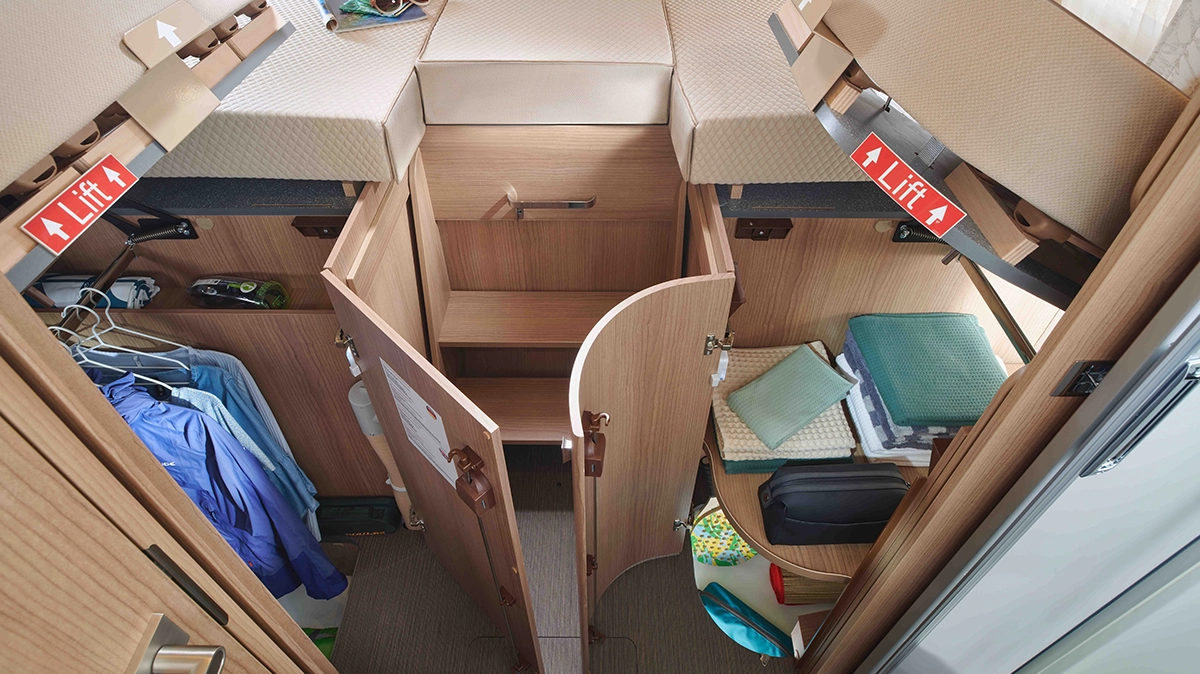 Längseinzelbetten mit darunterliegenden Kleiderschränken und Hinweis "Lift"