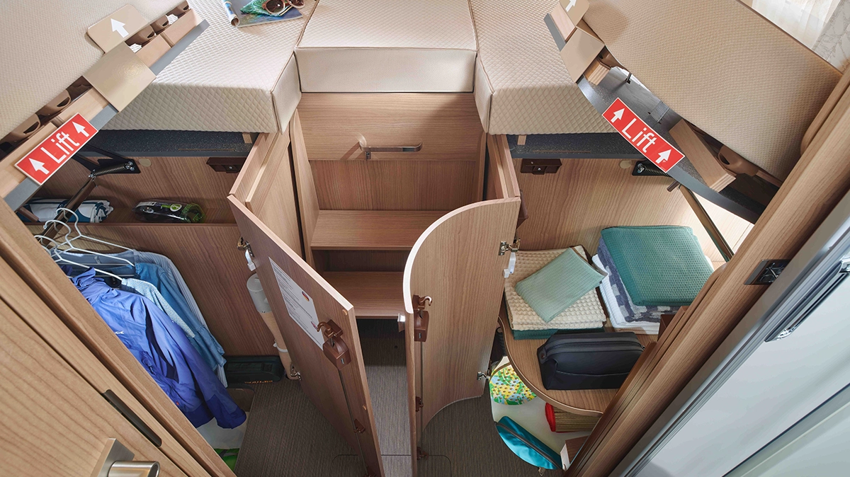 Längseinzelbetten mit darunterliegenden Kleiderschränken und Hinweis "Lift"