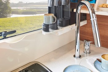 Detailansicht der Kaffeemaschine und des Wasserhahns in der Küche des Reisemobils