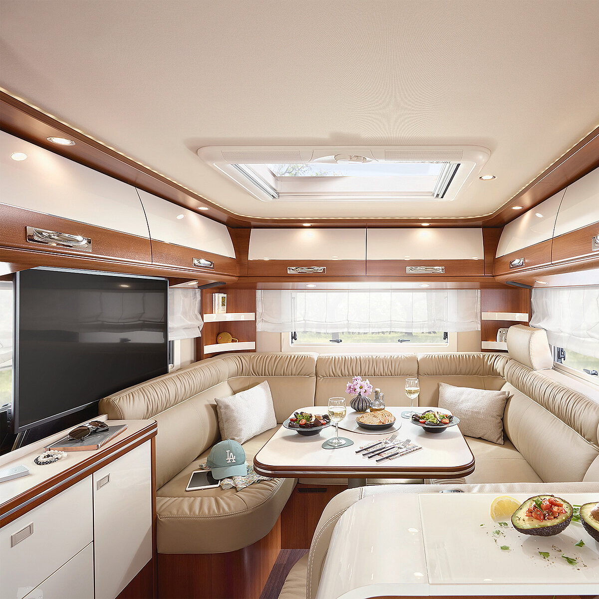 Ansicht des Sitzbereichs im Heck des Wohnmobils mit ausgefahrenem Fernseher