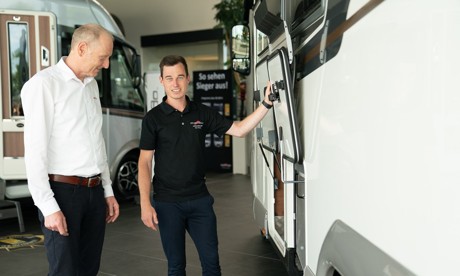 Mitarbeiter aus dem Werksverkauf in Aulendorf präsentieren ein Carthago Reisemobil 