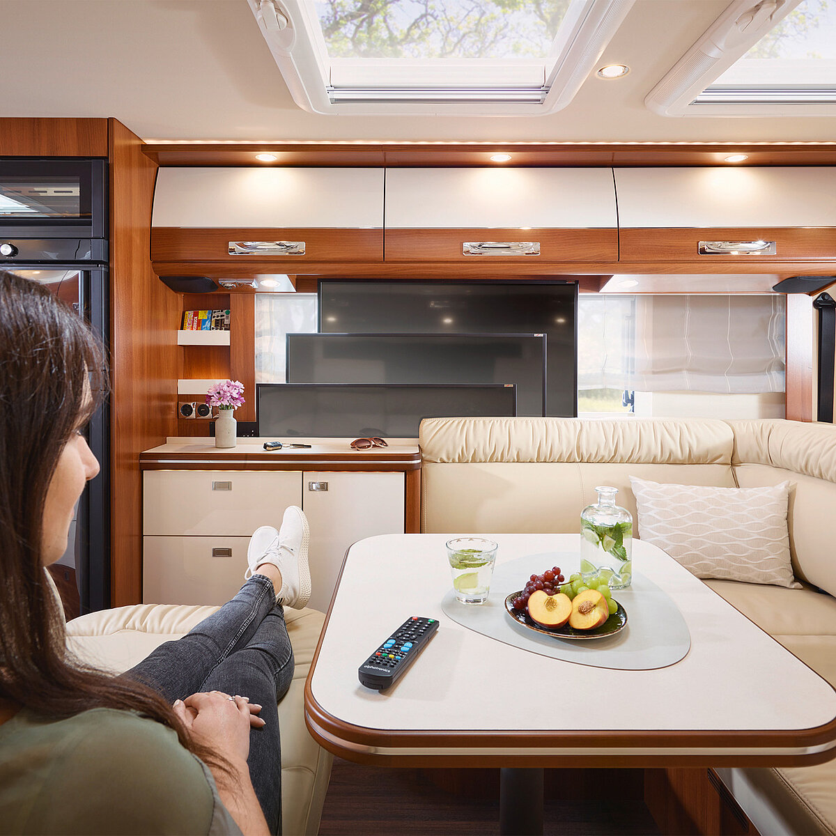 Detailaufnahme im Wohnbereich mit  Blick auf den Fernseher von der elektrisch ausfahrbaren Couch