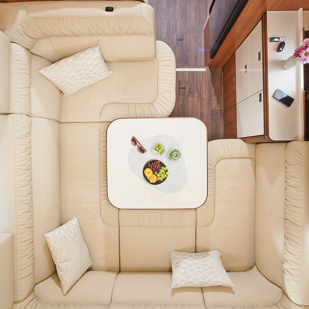 Draufsicht auf den Wohnraumtisch im Heckbereich des Wohnmobils inklusive Kissen