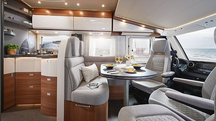 Wohnraum des Carthago C2-tourer mit Küche und Barschwung 