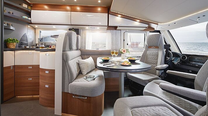 Wohnraum des Carthago C2-tourer mit Küche und Barschwung 