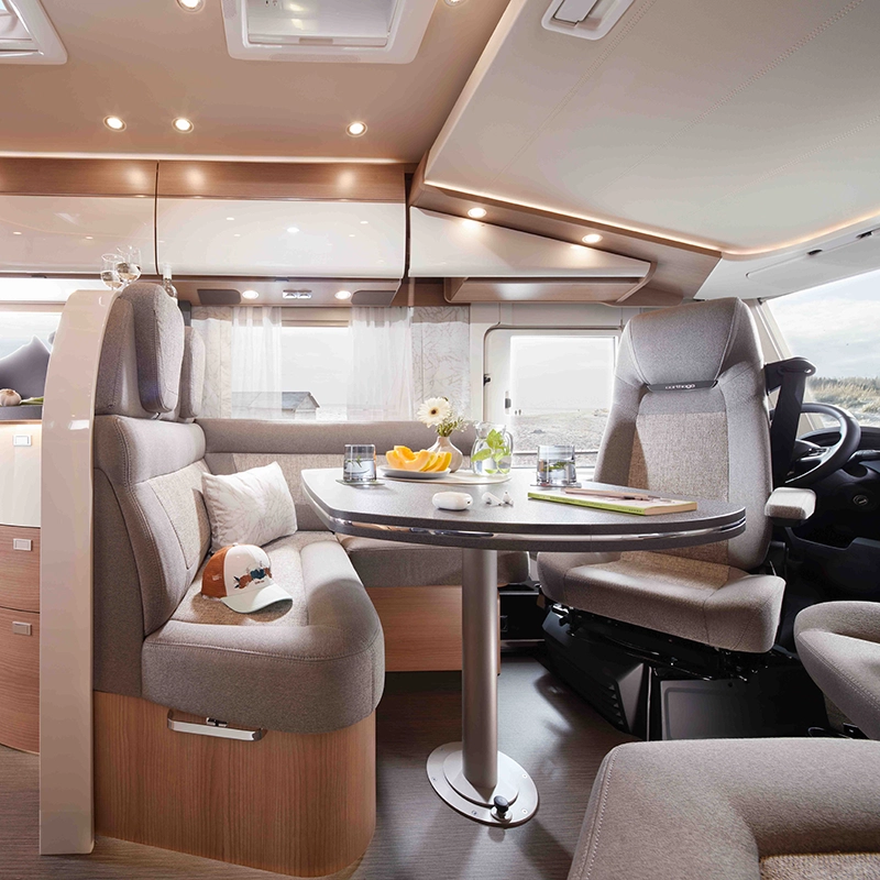 Carthago Sitzgruppe in grau mit gedecktem Tisch und Beleuchtung durch LED-Spots