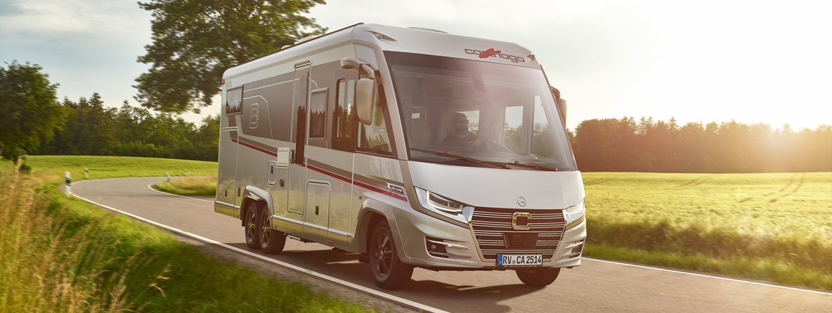 Fahraufnahme Carthago Wohnmobil e-line auf Straße mit Baum im Hintergrund