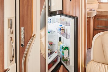 Eingangsbereich eines Reisemobils mit Blick auf den Kühlschrank und die integrierte Gefrierkombination