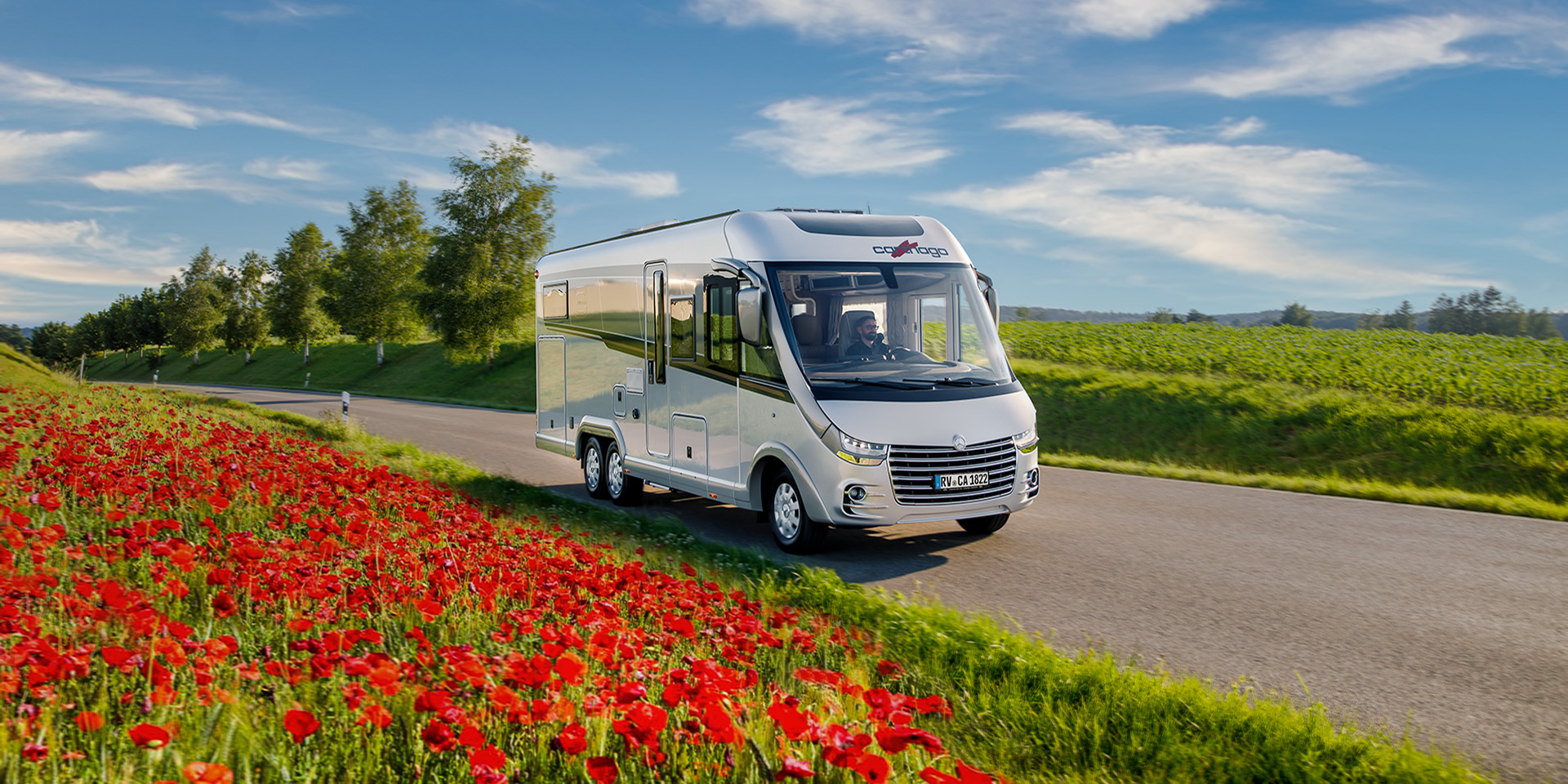 Vollintegriertes Wohnmobil chic-e-line-50-da-mercedes umgeben von roten Blumen