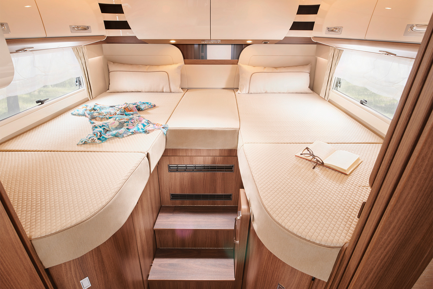 Schlafbereich eines integrierten Reisemobils mit Längeinzelbetten und vielen Dachschränken für optimalen Stauraumnutzen