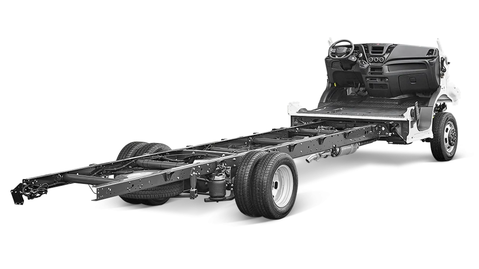 A vehicle chassis with an intact front cab and dashboard, but with the rear body and panels removed, exposing the frame and wheels against a black background.