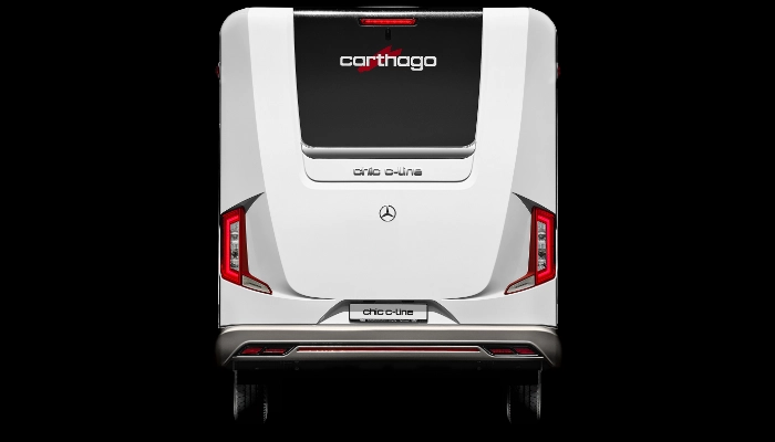 Rückansicht eines weißen Carthago-Wohnmobils mit markanten Rückleuchten, einer großen Heckscheibe mit dem Carthago-Logo und einem Mercedes-Benz-Emblem auf der Rückseite. Das Fahrzeug steht vor einem schwarzen Hintergrund.