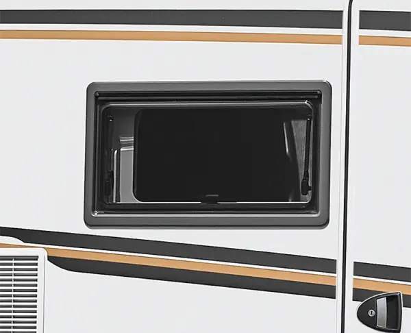 Ein kleines, rechteckiges, getöntes Fenster an der Seite eines weißen Wohnmobils, mit schwarzen, goldenen und grauen Zierstreifen, die diagonal darunter verlaufen.