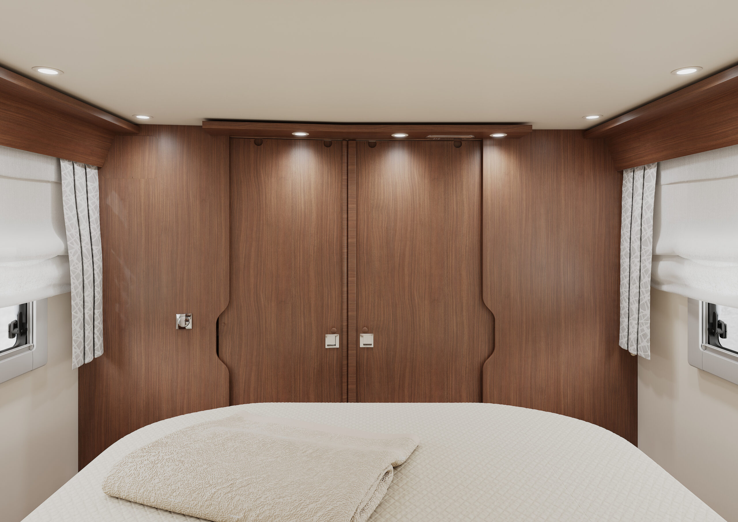 Ein gemütliches Schlafzimmer mit einer modernen Holzwand, eingelassener Beleuchtung, zwei kleinen Fenstern mit weißen Vorhängen und einem ordentlich gemachten Bett, das mit einer beigen Decke und einem gefalteten Handtuch bedeckt ist.