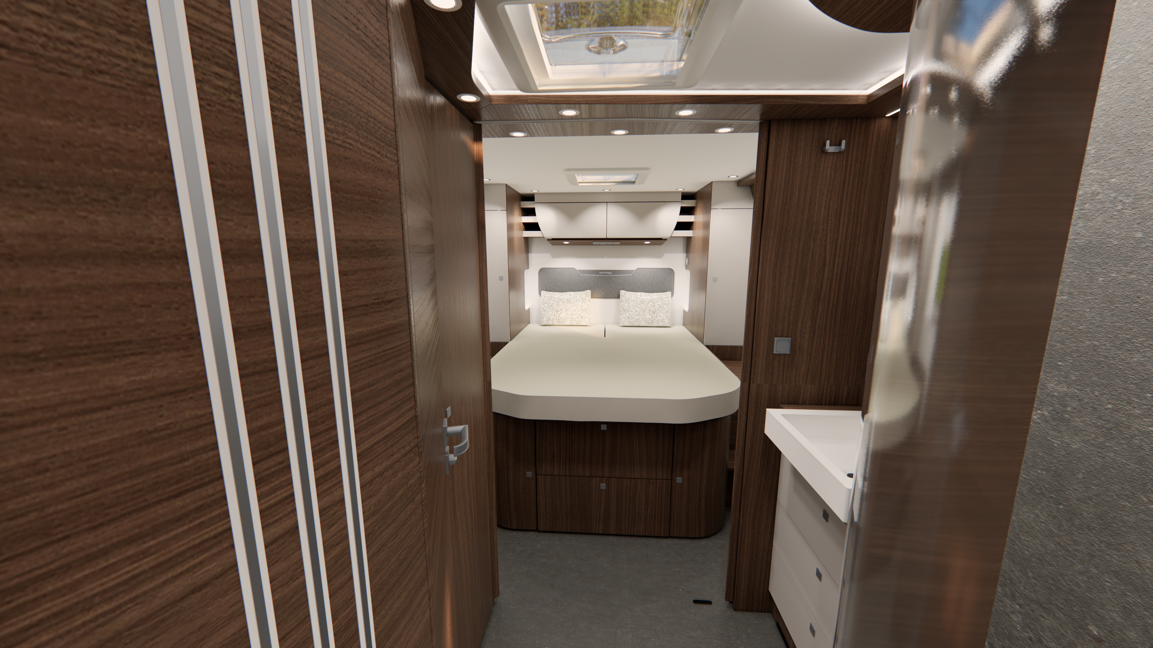 Innenansicht eines modernen Wohnmobil-Schlafzimmers mit einem Doppelbett, holzvertäfelten Wänden, Deckenbeleuchtung, weißen Schränken und einem kleinen Waschbecken auf der rechten Seite. Über dem Bett befindet sich ein Dachfenster, und die Kissen sind ordentlich angeordnet.