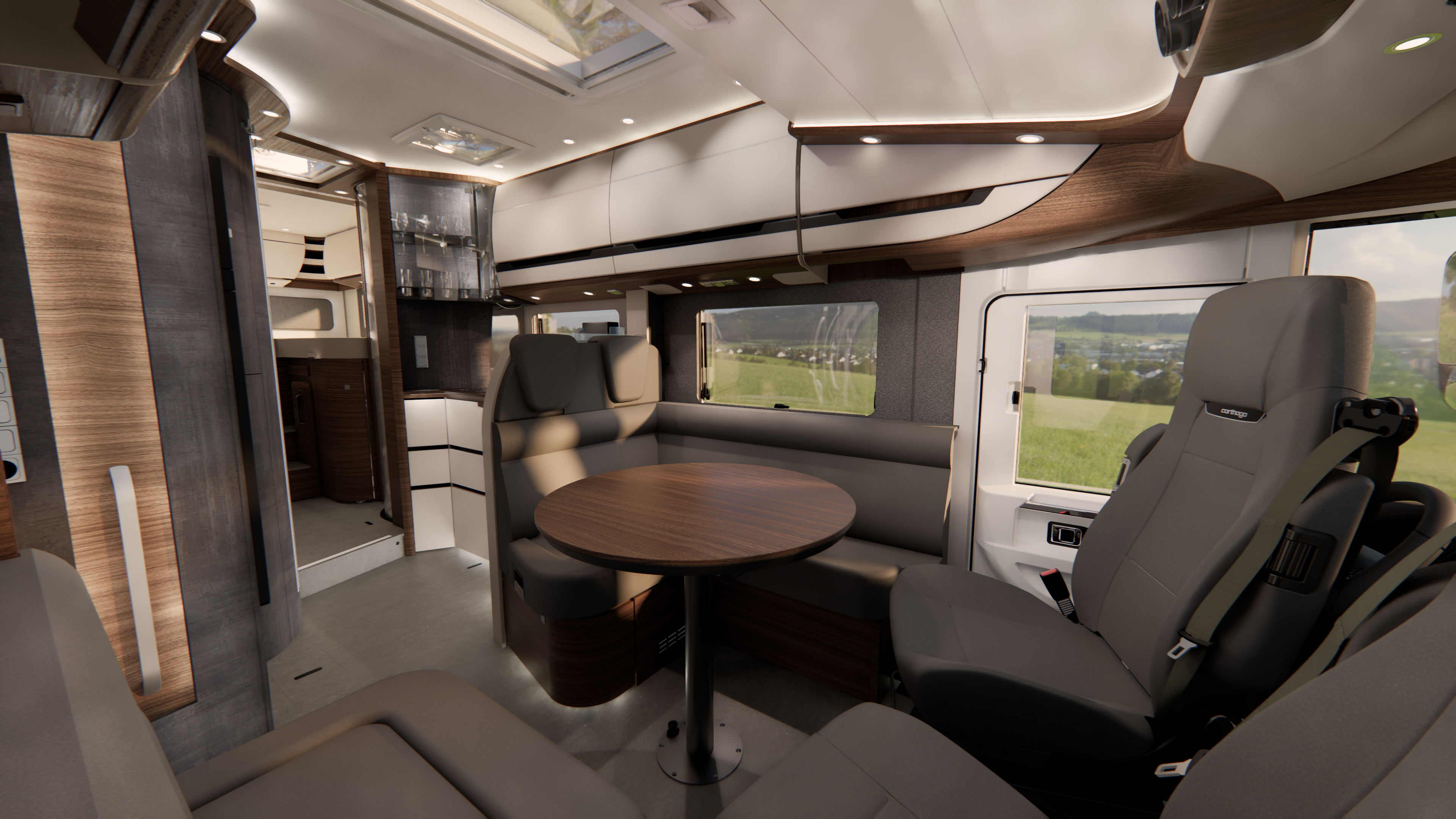 Moderne Wohnmobil-Innenausstattung mit grauen Sitzen, einem runden Holztisch, großen Fenstern mit Blick auf grüne Felder, Stauraum an der Decke und integrierter Beleuchtung, die einen gemütlichen und funktionalen Wohnraum schaffen.
