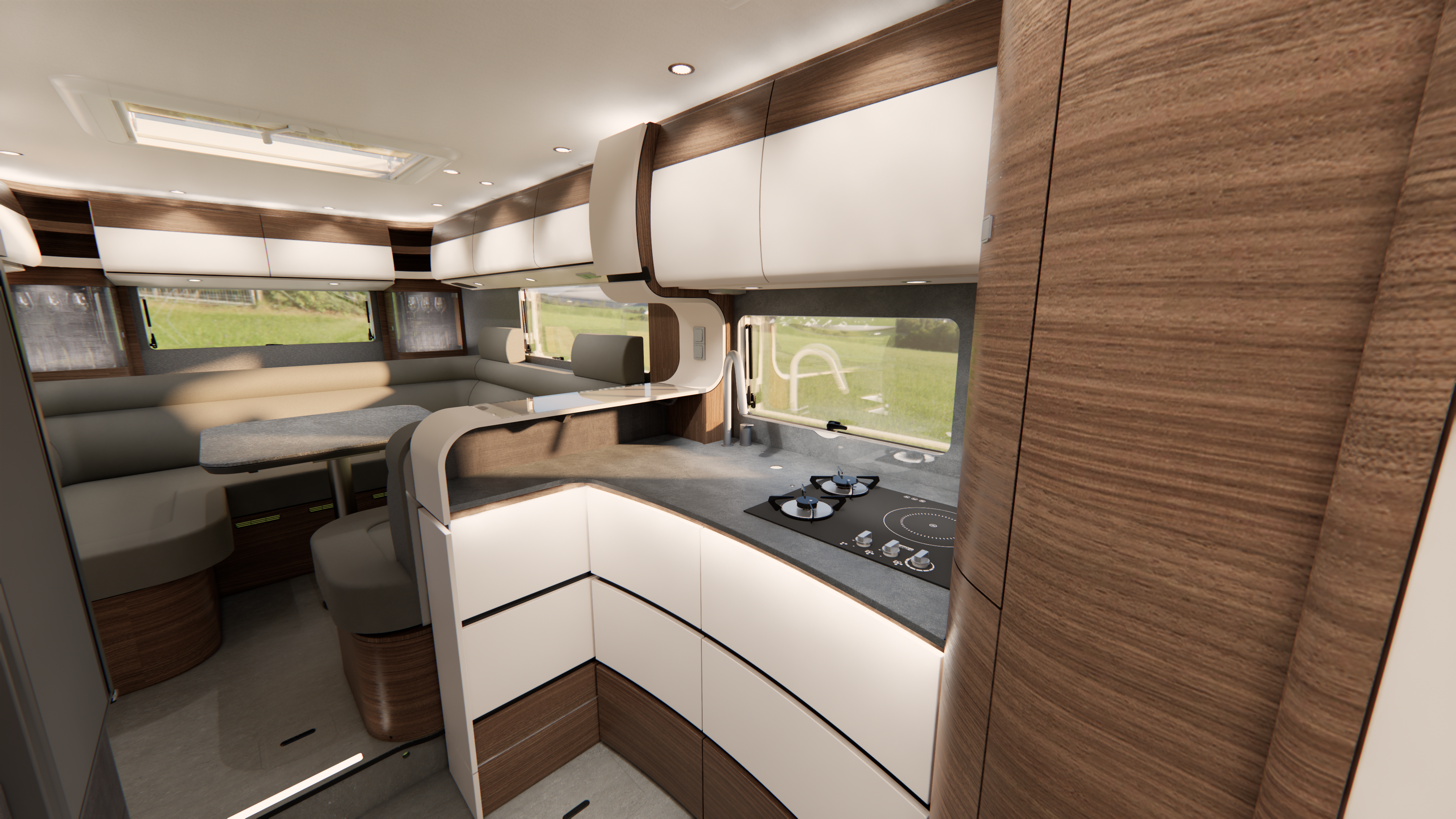 Moderne Wohnmobil-Innenausstattung mit Schränken aus Holz und in Weiß, einer kompakten Küche mit Herd sowie einem Essbereich mit großen Fenstern, die für Tageslicht sorgen und den Blick auf das grüne Gras draußen freigeben.