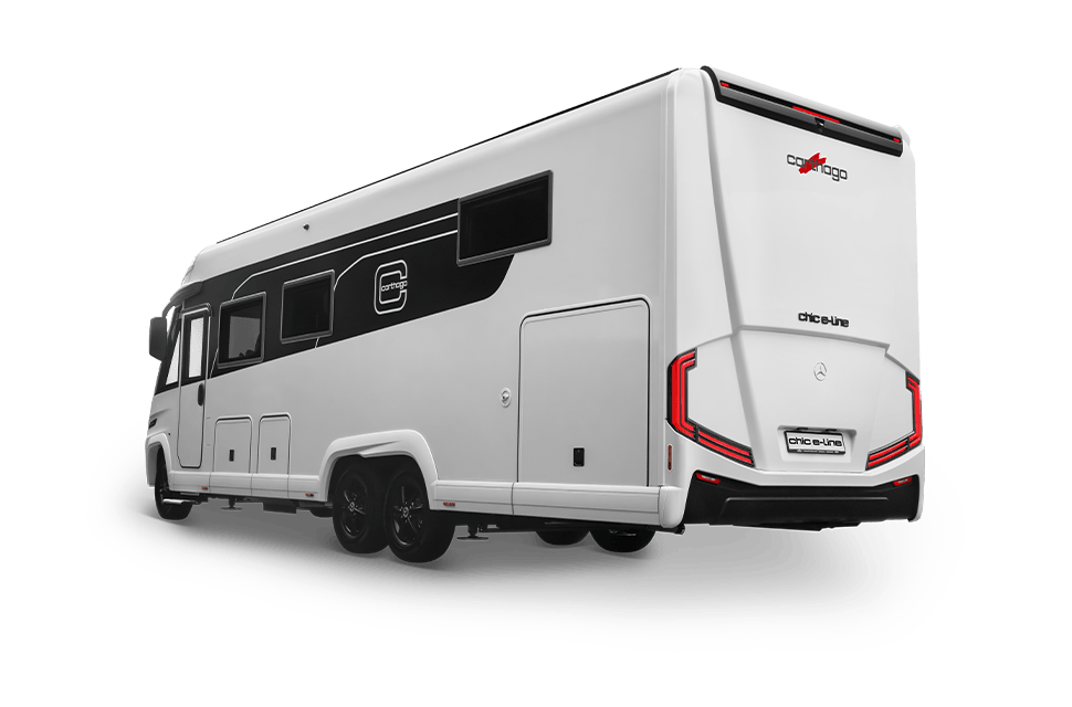 Ein modernes, weißes Wohnmobil mit schwarzen Akzenten ist aus einem seitlichen Heckwinkel zu sehen; es verfügt über große Fenster, Doppelhinterräder und markante Rückleuchten.