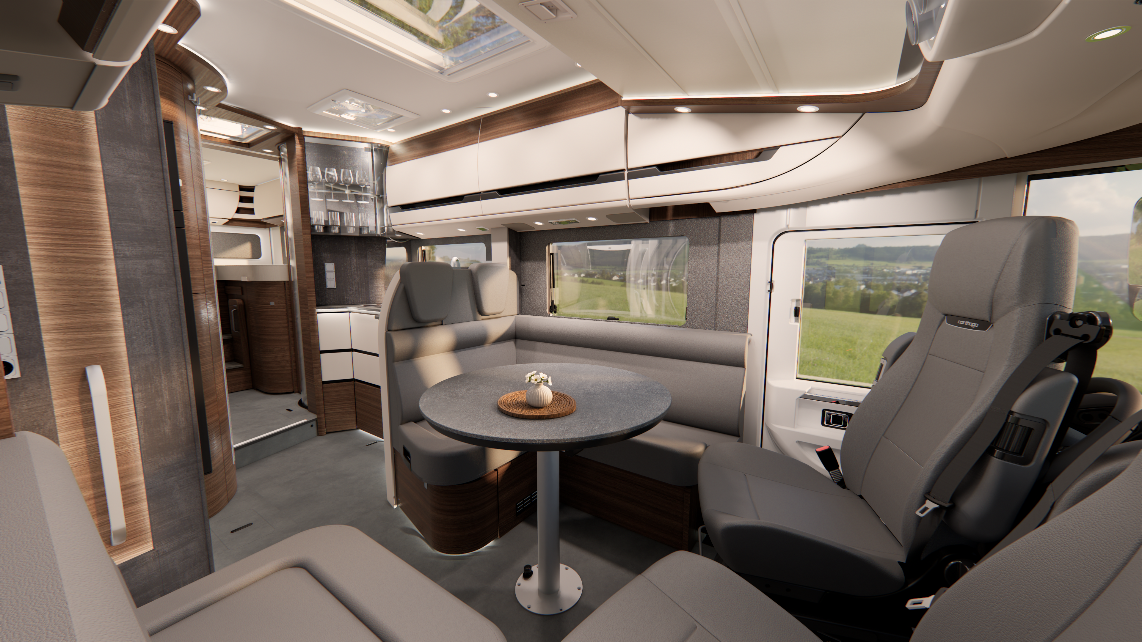 Moderner Wohnmobil-Innenraum mit grauen Ledersitzen, die um einen runden Tisch mit einer kleinen Pflanze angeordnet sind. Große Fenster bieten einen malerischen Blick auf grüne Felder. Holzakzente und elegante Beleuchtung schaffen eine gemütliche, moderne Atmosphäre.