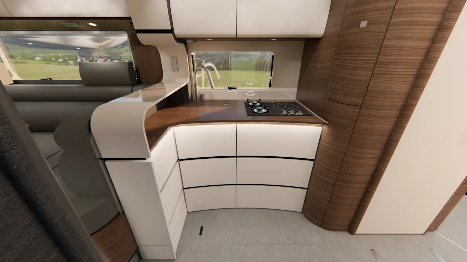 Moderne Wohnmobilküche mit geschwungenen Schränken, einer Farbgebung in Braun und Weiß, einem Einbau-Kochfeld, einem Fenster über der Arbeitsplatte und einem eleganten, minimalistischen Design. Durch das Fenster bietet sich ein Blick auf die Landschaft, was den raffinierten Stil des Carthago Liner for Two widerspiegelt.