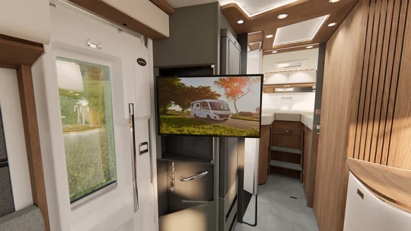 Innenraum eines modernen Wohnmobils mit Holzakzenten, einem an der Wand montierten Fernseher, auf dem ein Carthago C2-Tourer auf einer malerischen Straße zu sehen ist, einer kleinen Treppe, einem Fenster und eleganten Stauschränken.