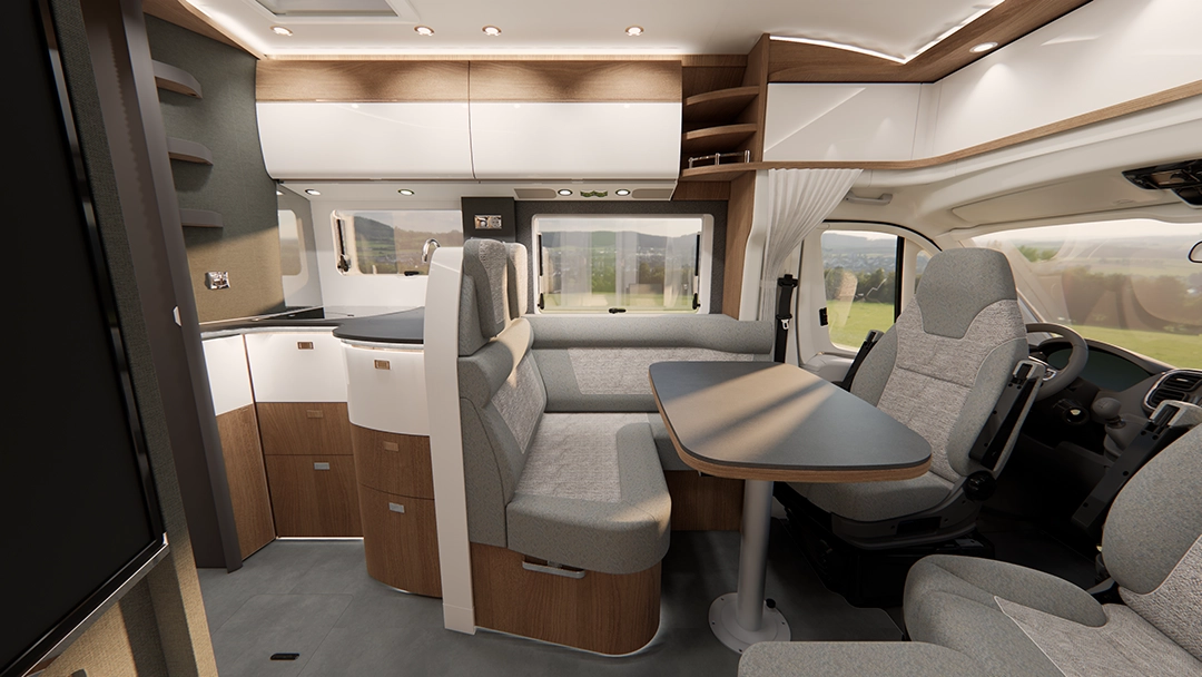 Innenansicht eines teilintegrierten Wohnmobils vom Typ Carthago c-tourer mit einem Essbereich, bestehend aus einem Tisch, zwei Sitzbänken und zwei drehbaren Sitzen im Fahrerhaus.